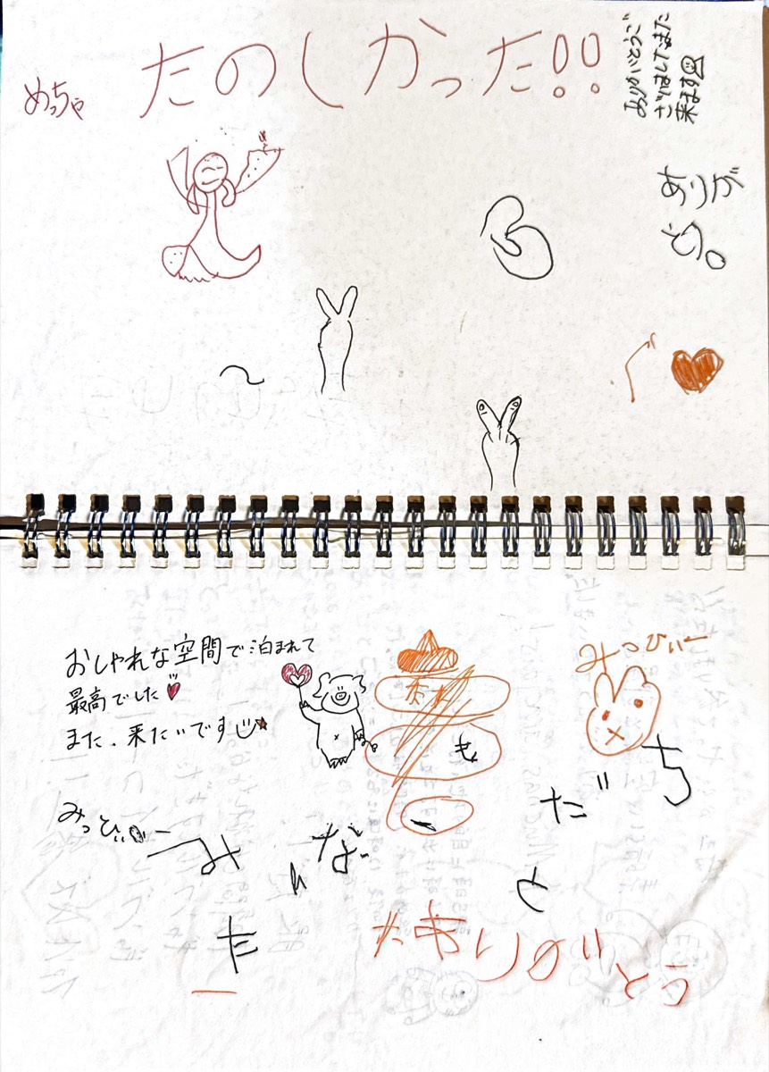 A guest notebook page filled with handwritten drawings and messages.