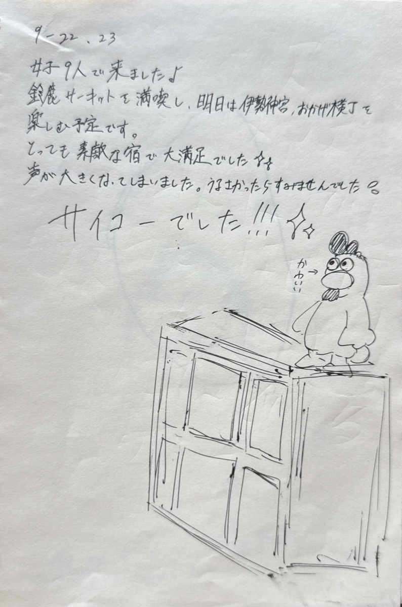 A guest notebook page with a review and a drawing of the house.