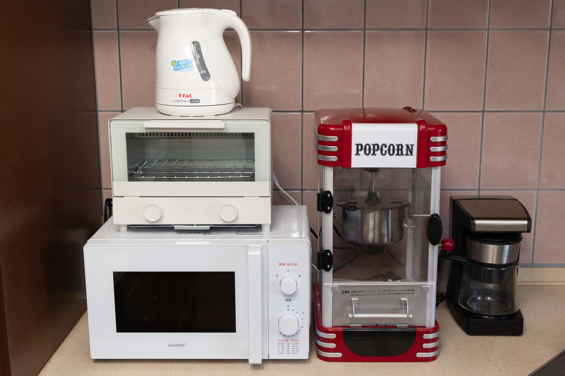 The kitchen counter — popcorn maker, microwave, toaster oven, electric kettle and coffee maker.